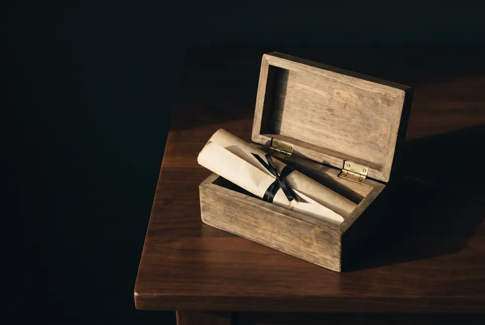 Coffret ancien ouvert sur un acte plié noué d’un ruban